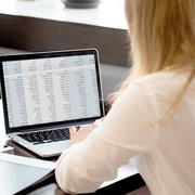 Eine Frau von hinten, die an einem Laptop arbeitet